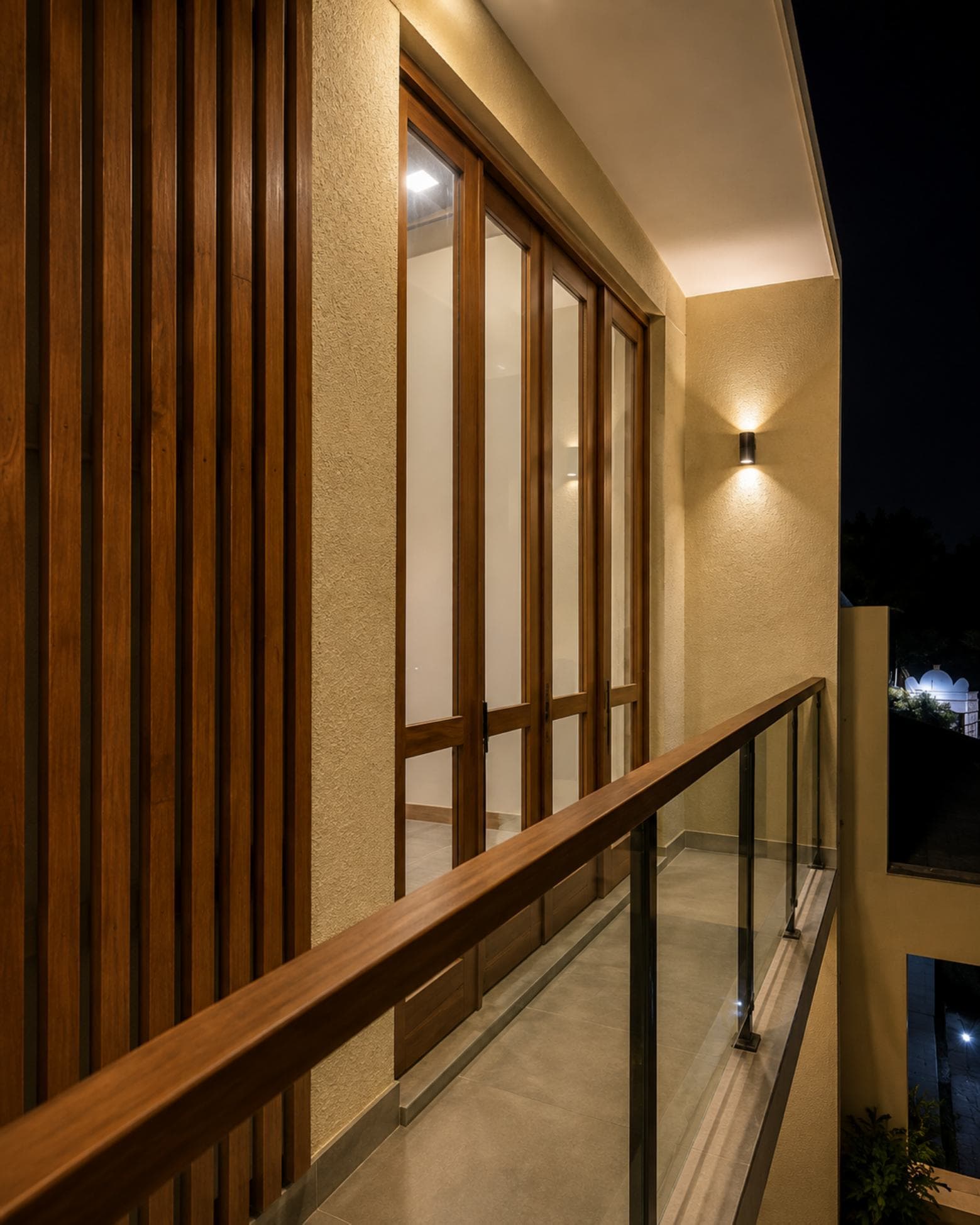 No. 11/11A, Saman Mawatha, Sirimal Uyana — night view along the balcony, glazed doors and timber slat screen